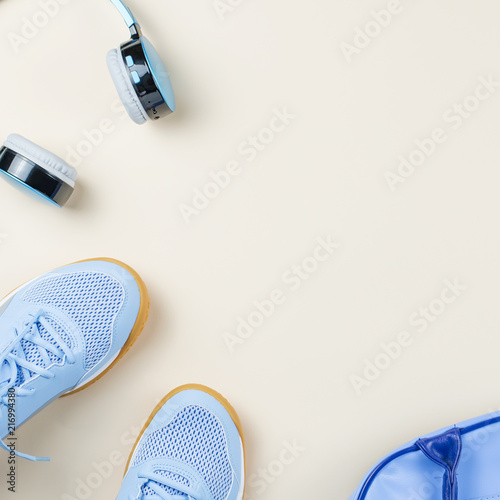 Woman sneakers, headphones, sport bag on pastel background. Sport fashion concept. Flat lay