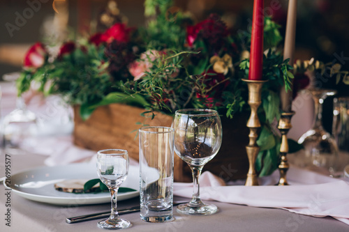 a wedding table with cutlery, candles and flowers.