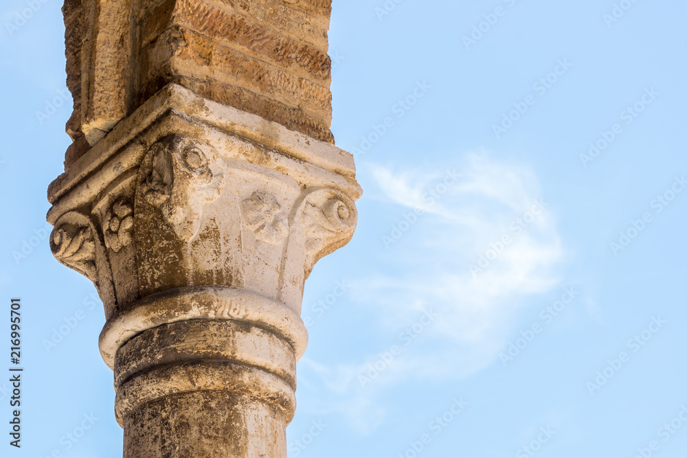 Corinthian order capital on blue sky. The capital belongs to the fifteenth-century portico of the collegiate Church of San Michele Arcangelo, a medieval religious complex located in Città Sant'Angelo