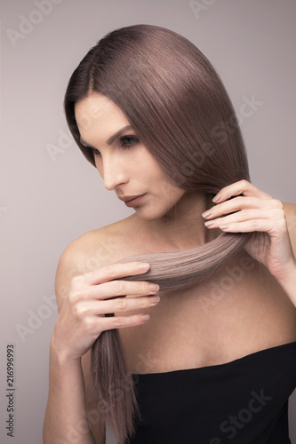 Vertical studio shot of a girl with long purple blonde hair. © Max