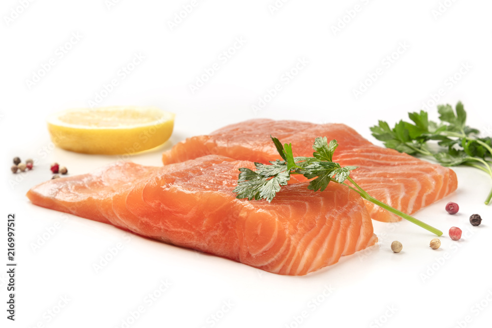 Slices of salmon with lemon, parsley, and pepper, on a white background with copy space Slices of salmon with lemon, parsley, and pepper, on a white background with copy space