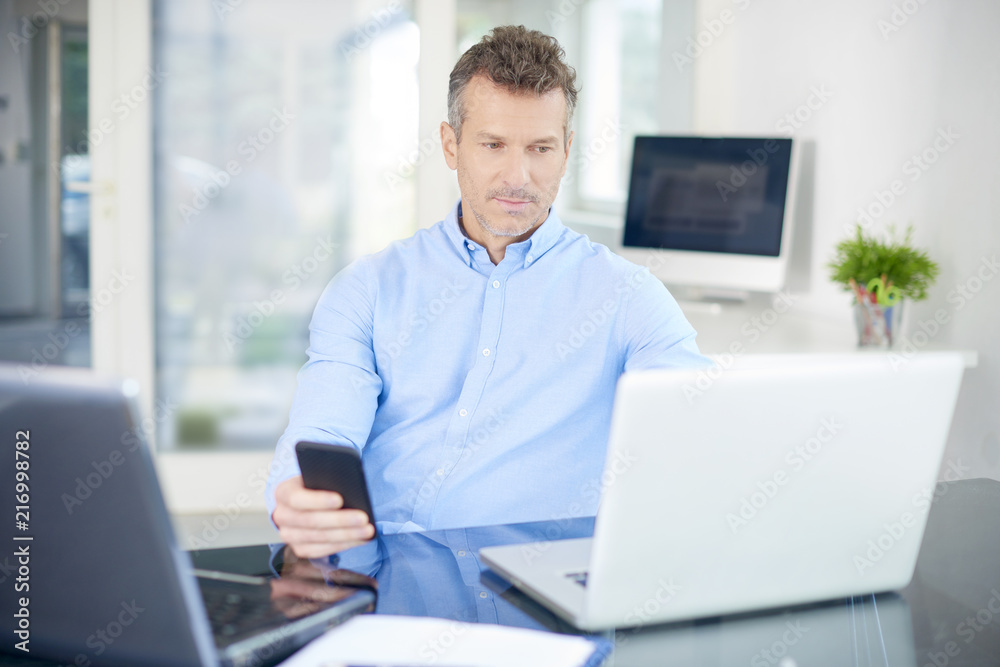Professional man working in the office and text messaging Professional man working in the office and text messaging
