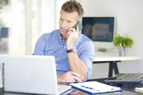 Businessman with mobile phone and notebook in the office