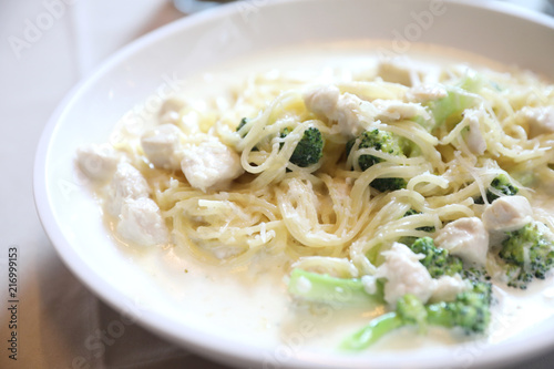 alfredo spaghetti broccoli chicken white sauce in restaurant background