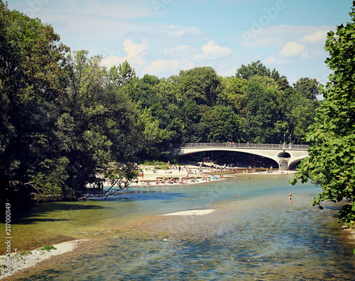 Munich, Germany - people take a bath in the clean waters of Isar river near  Kabelsteg bridge in Munich center city photo