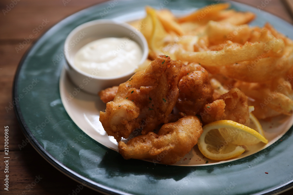 Fish and chips fried fish and potatoes on wood background vintage style Fish and chips fried fish and potatoes on wood background vintage style