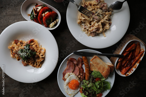 food flat lay top view with pasta and english breakfast on wood background