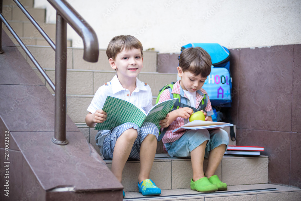 Children go back to school. Start of new school year after summer vacation.  Two Boy friends with backpack and books on first school day Photos | Adobe  Stock