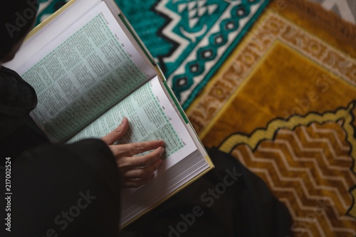 Muslim woman reading holy Quran photo