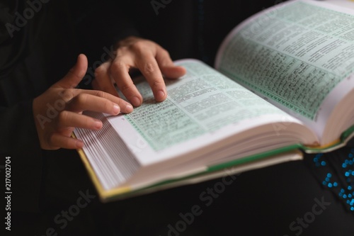 Muslim mother and daughter reading holy Quran
