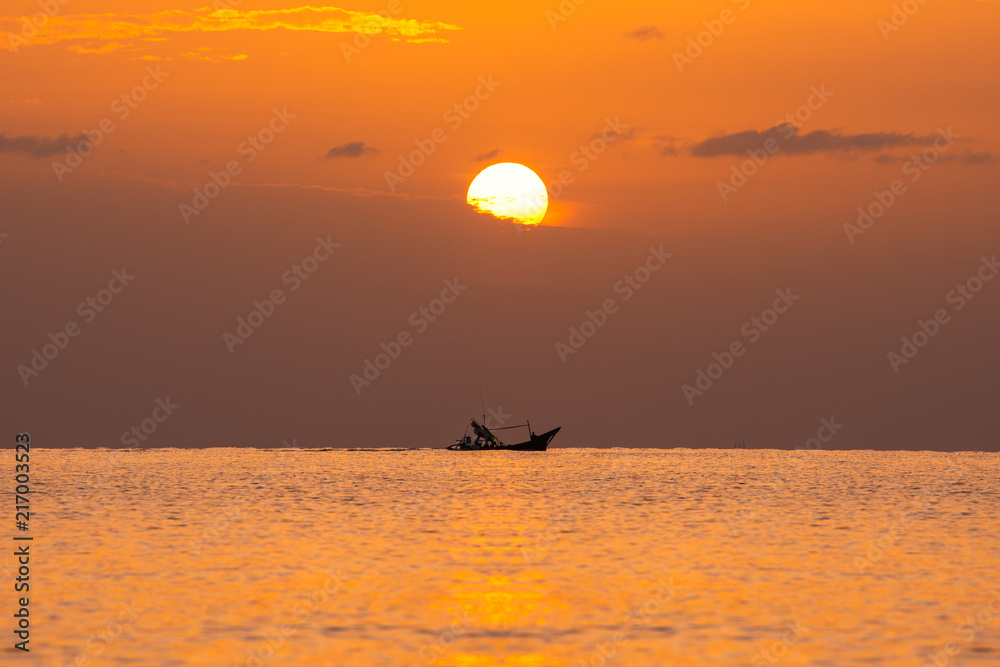 small wooden boat in sea with sunrise