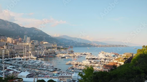 Beautiful view to marina with a lot of yachts and boats and picturesque mountain landscape softly lit by evening sun on the background of Monaco city. photo