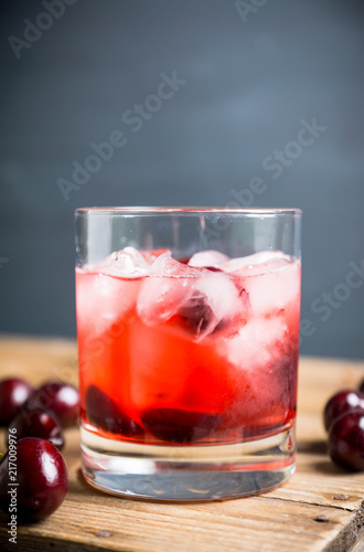 Old fashioned cocktail with cherry. Selective focus.