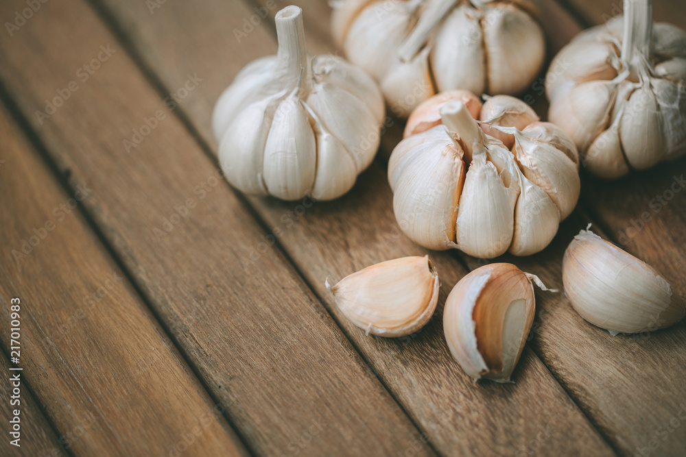 Garlic and cloves upper right corner on wooden background Garlic and cloves upper right corner on wooden background