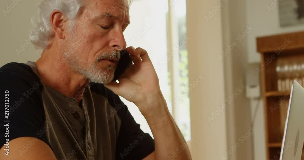 Senior man talking on mobile phone at home 4k Senior man talking on mobile phone at home 4k