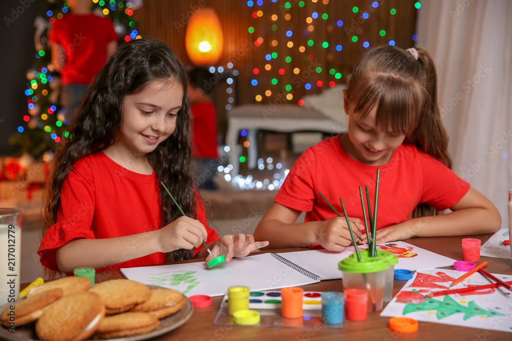 Fototapeta premium Little children painting pictures at home. Christmas celebration