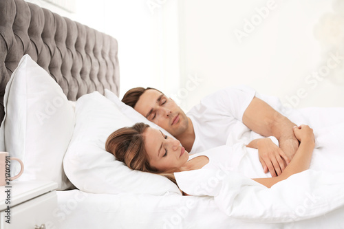 Young couple sleeping on soft pillows in bed at home