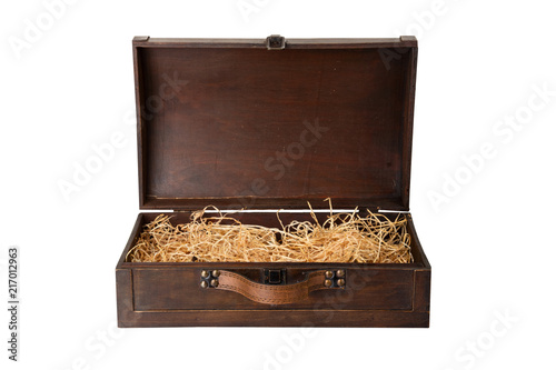 Opened old wooden chest with a leather handle, filled with wood wool isolated on white background. Space for text display montage.