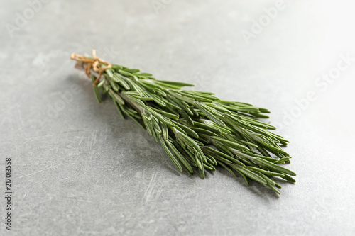 Fototapeta Naklejka Na Ścianę i Meble -  Fresh rosemary twigs tied with twine on gray table, closeup