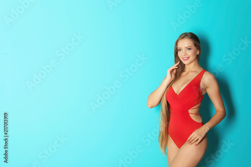 Beautiful woman wearing bikini on color background