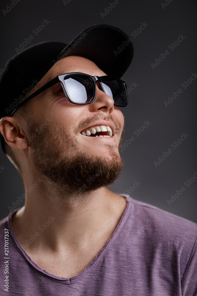 young bearded man in cap and sunglasses
