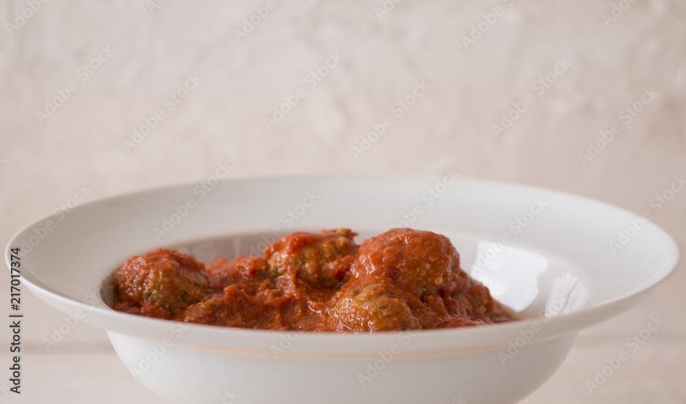 A white dish with meat balls. A white dish with meat balls.