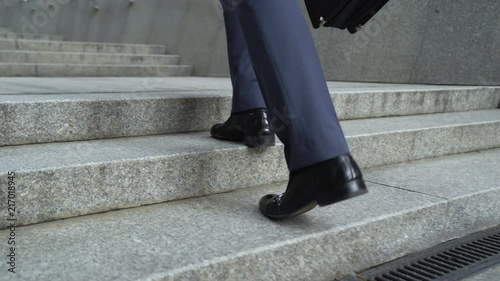 Closeup of businessman climbing stairs, concept of success in career, promotion photo