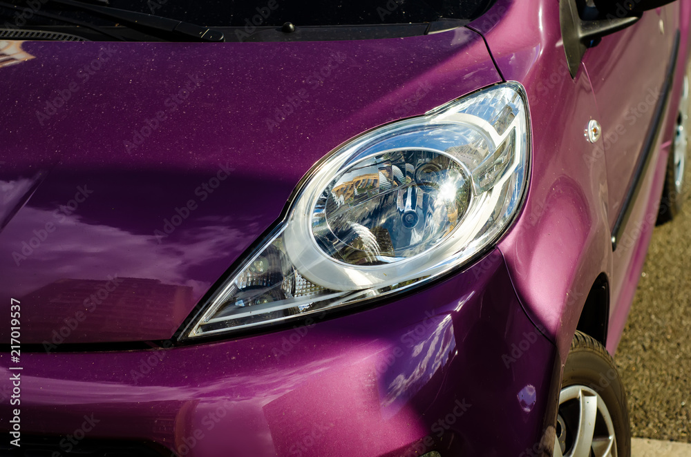 Car head light red lilac in the street