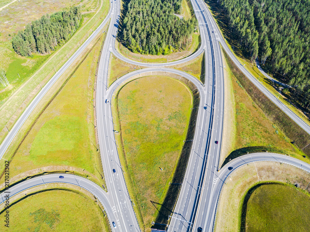 Aerial view of highway in city. Cars crossing interchange overpass. Highway interchange with traffic. Aerial bird's eye photo of highway. Expressway. Road junctions. Car passing. Top view from above.