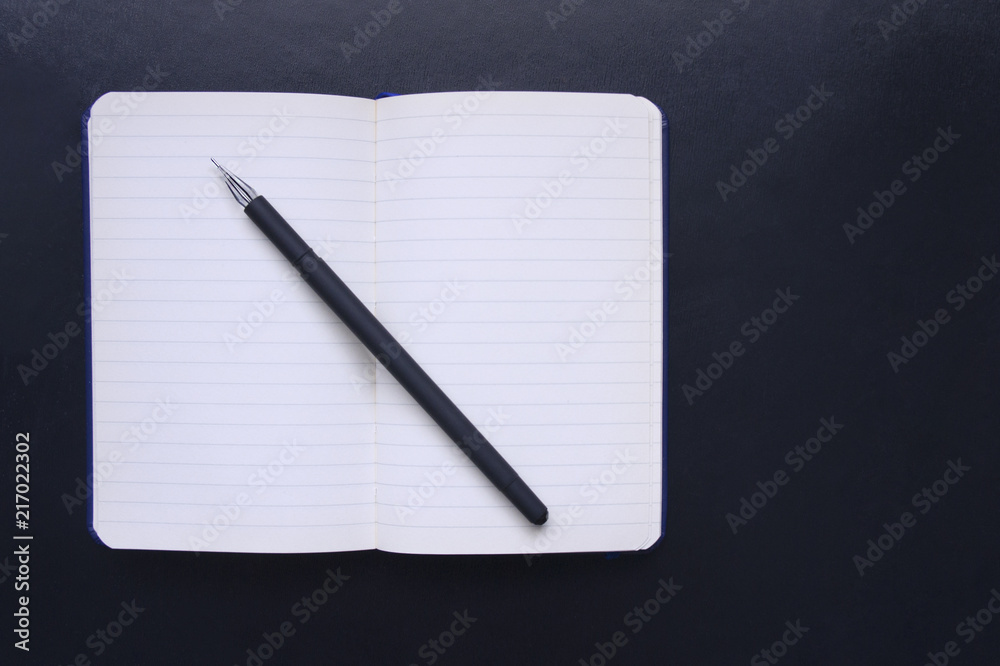 Notepad with line and pen on a black background. Notebook and pen. A man's notepad. Back to school, the classic strict style. Business concept, Paper for notes, Office chancery