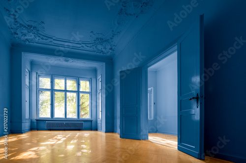 empty room in old apartment building with  parquet floor  and blue painted walls