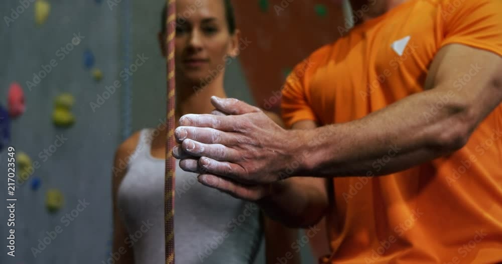 Coach dusting chalk powder from his hands at bouldering gym 4k Coach dusting chalk powder from his hands at bouldering gym 4k