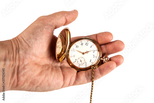 man's hand holds a vintage gold pocket watch on a white background