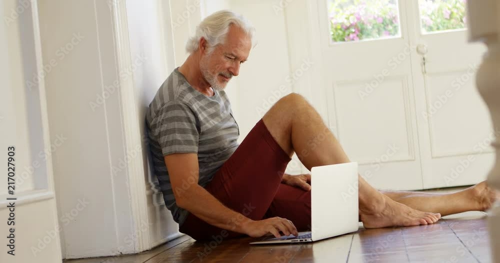 Senior man using laptop at home 4k