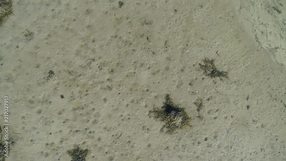 Pan out drone shot of a sandy beach mostly under water Pan out drone shot of a sandy beach mostly under water