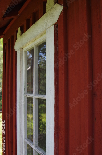 White window in a red wooden house