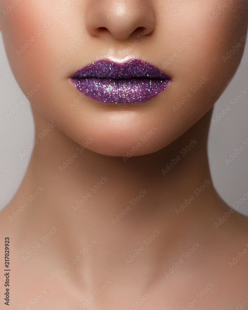 Obraz premium Close-up of woman's lips with bright fashion pink glossy makeup. Macro magenta lipgloss make-up. Sexy pink lip makeup. Highly saturated color. Lipstick