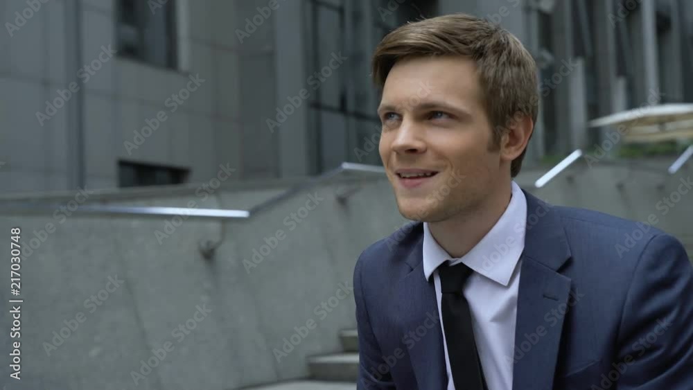 Successful businessman working on laptop, sitting on stairs outdoors, ambitions Successful businessman working on laptop, sitting on stairs outdoors, ambitions