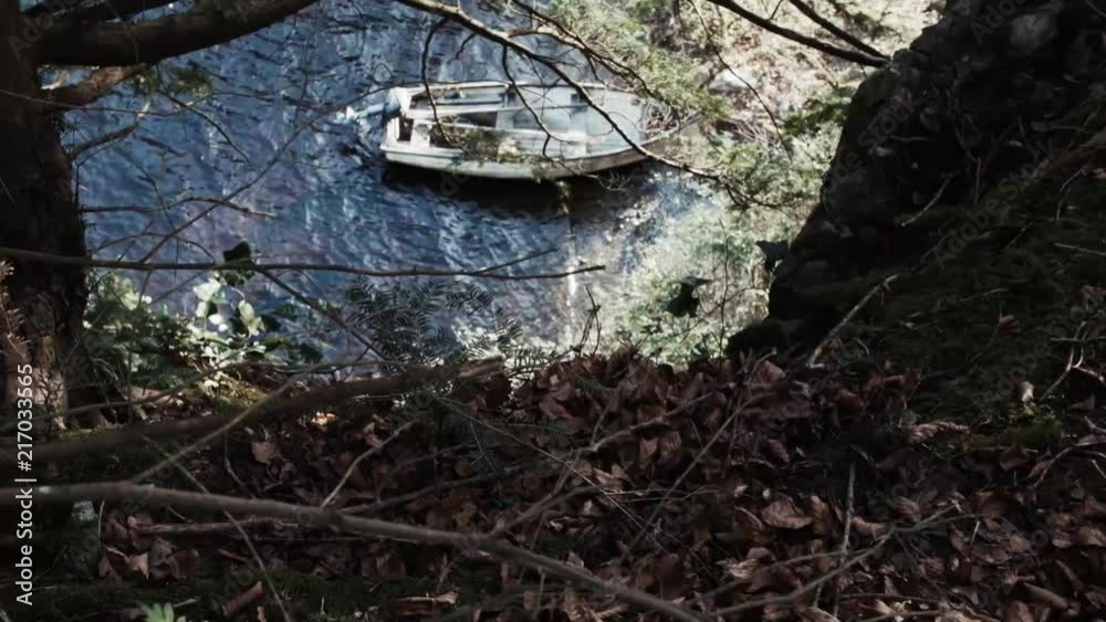 High angle shot overlooking boat beached on shore in wooded area. High angle shot overlooking boat beached on shore in wooded area.