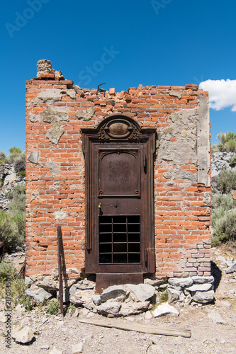 Ornate rusted iron door in the brick wall of the ruined bank vault in the ghost town of Bodie, California