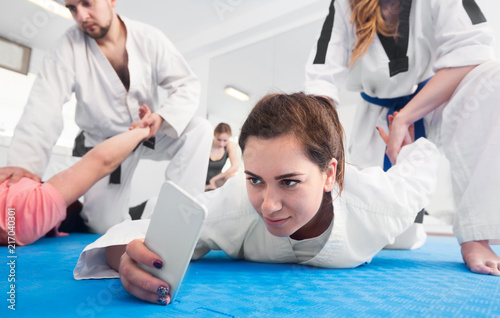 Adults taking photos while practicing taekwondo holds