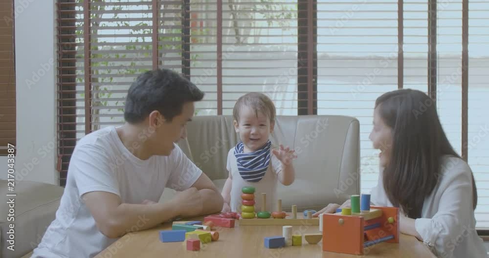 Happy mother, father and little asian boy playing with wooden toy blocks at home. Educational Toys for preschool and kindergarten child. Happy mother, father and little asian boy playing with wooden toy blocks at home. Educational Toys for preschool and kindergarten child.