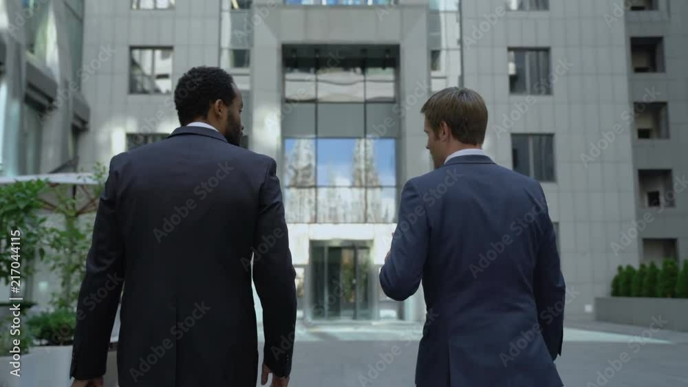 Colleagues economists going to work together, discussing changes in stock market Colleagues economists going to work together, discussing changes in stock market