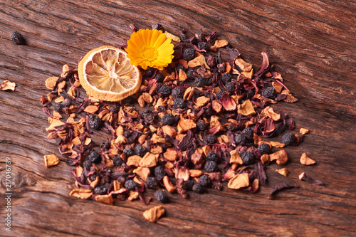 Black dry fruit tea leaves on wooden table. Selective focus photo