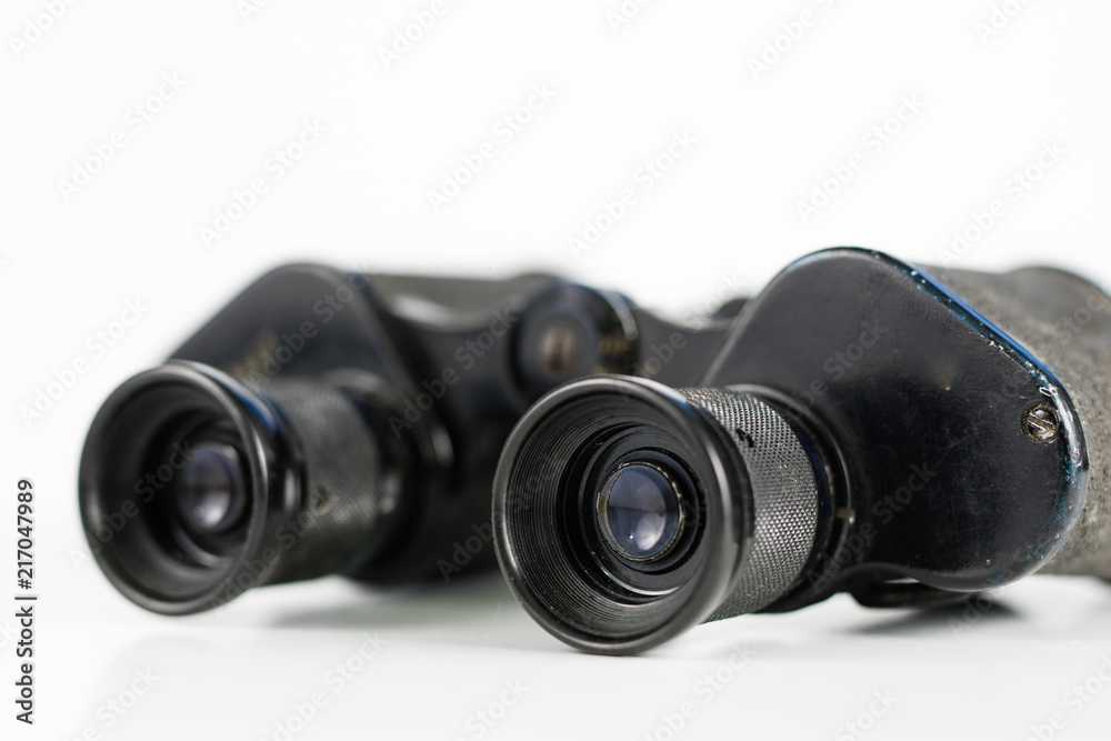 Old metal binoculars on a white table. Old military accessories for infantry. Old metal binoculars on a white table. Old military accessories for infantry.