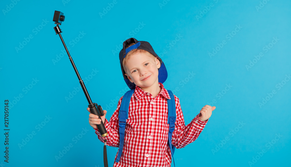 portrait of little funny school blogger boy with action camera. Hipster. concept social networks, education and travel portrait of little funny school blogger boy with action camera. Hipster. concept social networks, education and travel