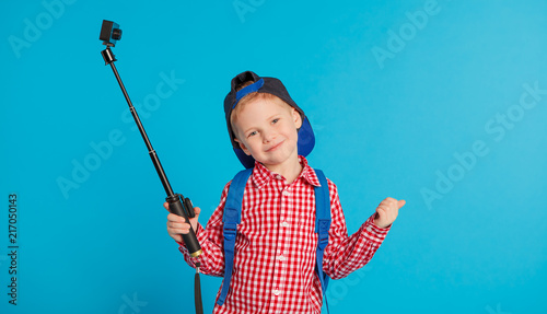 portrait of little funny school blogger boy with action camera. Hipster. concept social networks, education and travel