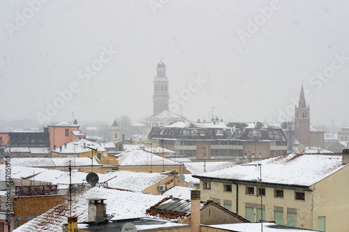 Winter unusual aerial landscape of Rovigo in Veneto in the Po valley, Italy. During a snowfall the city roofs got white even the historic landmark as the Rotonda church and its bell tower photo
