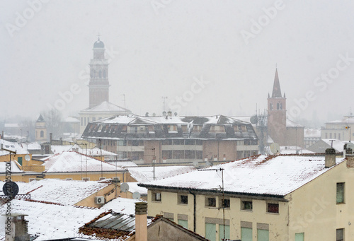 Winter unusual aerial landscape of Rovigo in Veneto in the Po valley, Italy. During a snowfall the city roofs got white even the historic landmark as the Rotonda church and its bell tower photo