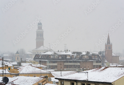 Winter unusual aerial landscape of Rovigo in Veneto in the Po valley, Italy. During a snowfall the city roofs got white even the historic landmark as the Rotonda church and its bell tower photo